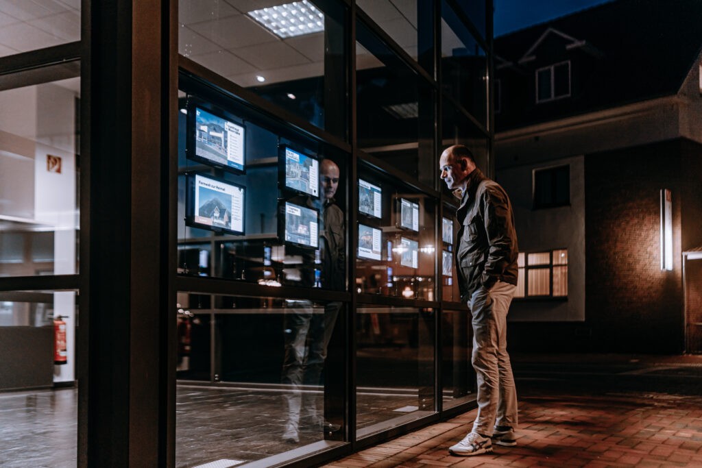 A passerby viewing digital property listings